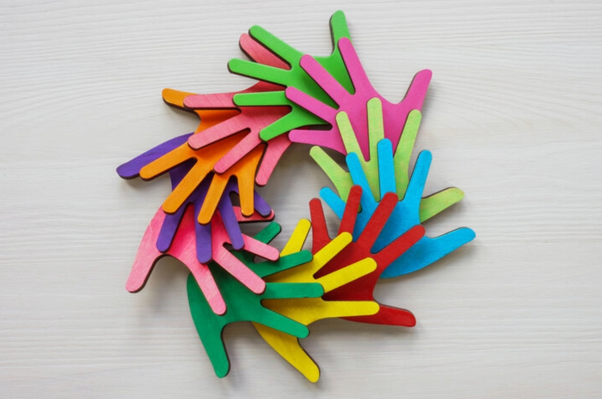Colorful hand-shaped cutouts arranged in a circular pattern, overlapping.