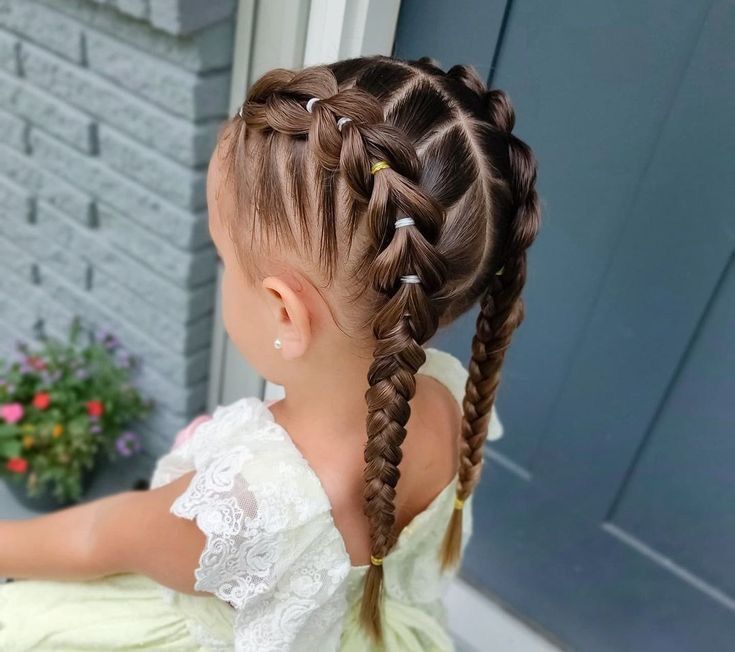 Ein kleines Mädchen trägt zwei Zöpfe im Haar.