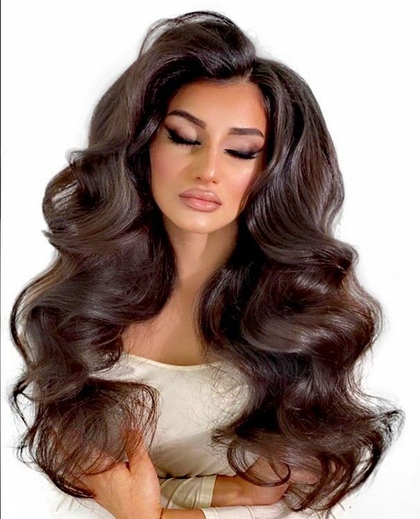 Eine Frau mit sehr langen braunen Haaren trägt ein weißes Kleid.