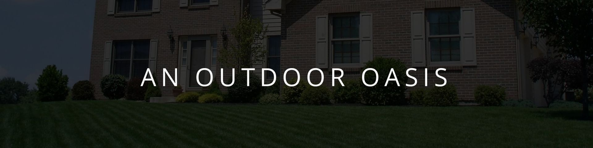Banner reading “An Outdoor Oasis” over a building at dusk