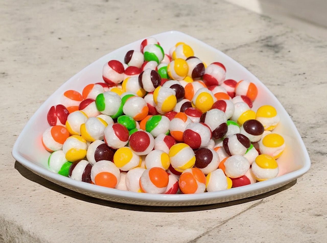 A white plate filled with colorful candy balls