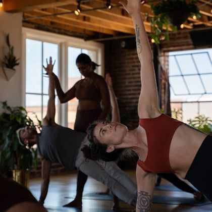 Yoga class practicing side plank poses in a sunlit studio