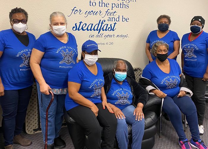 A group of women wearing face masks are posing for a picture.