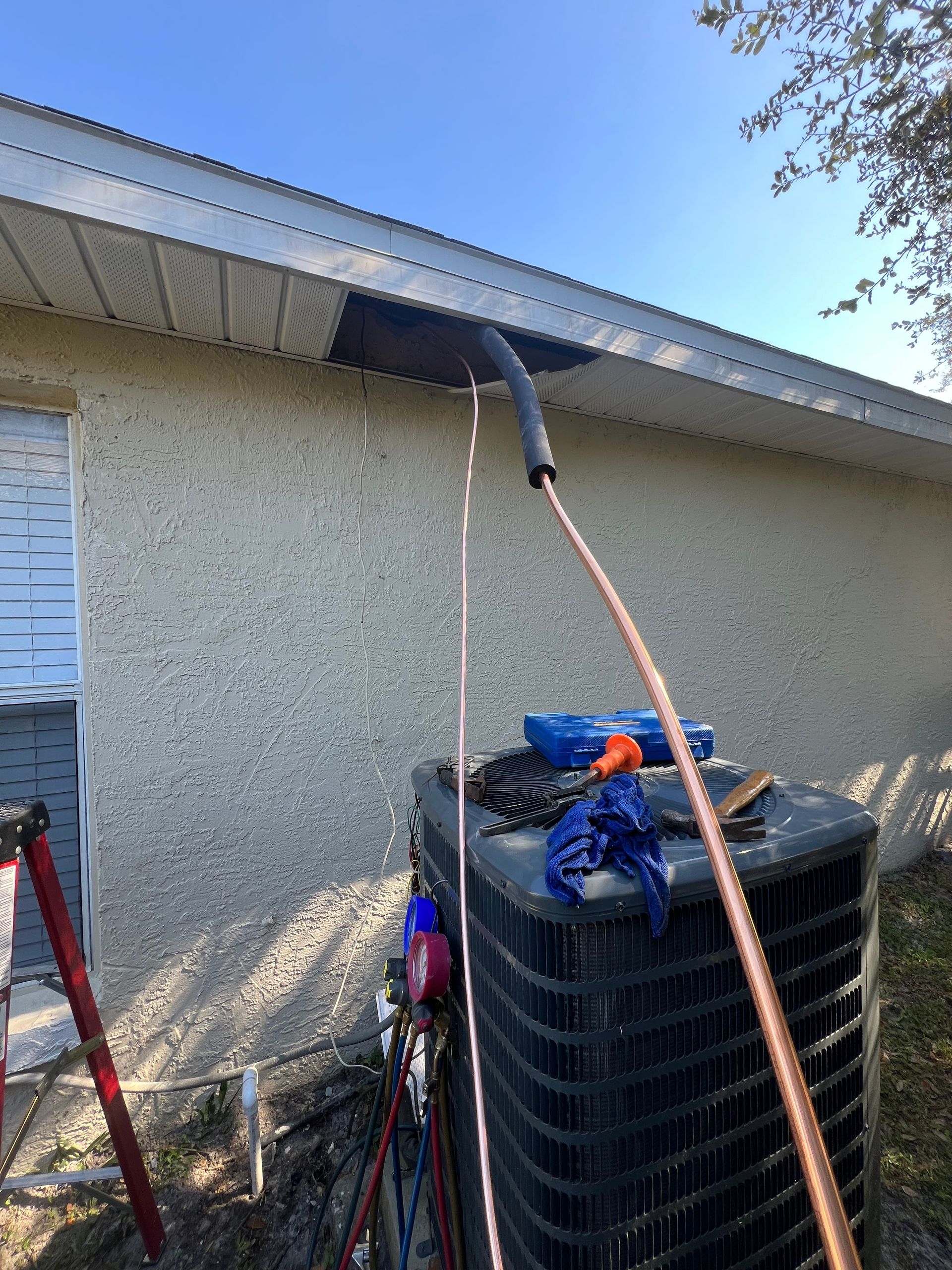 a hose is hanging from the roof of a house next to an air conditioner .