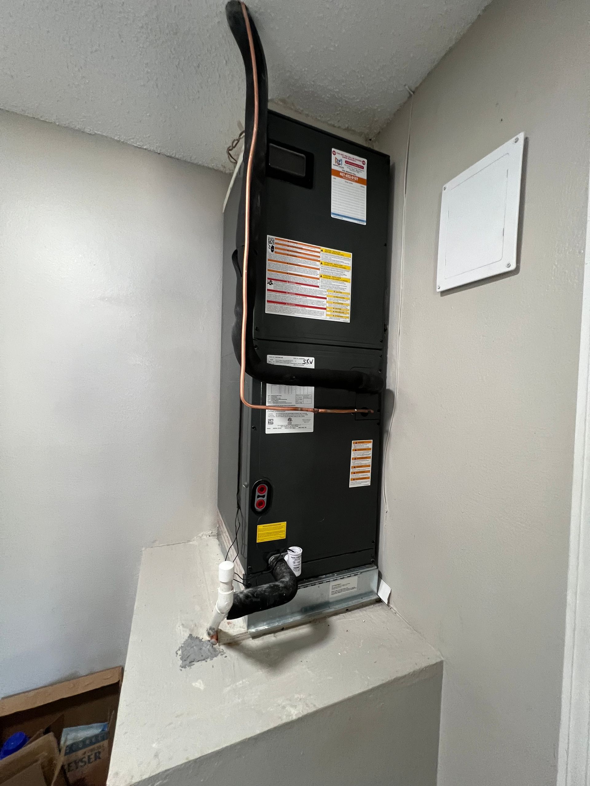 a black air conditioner is mounted on a wall in a room .