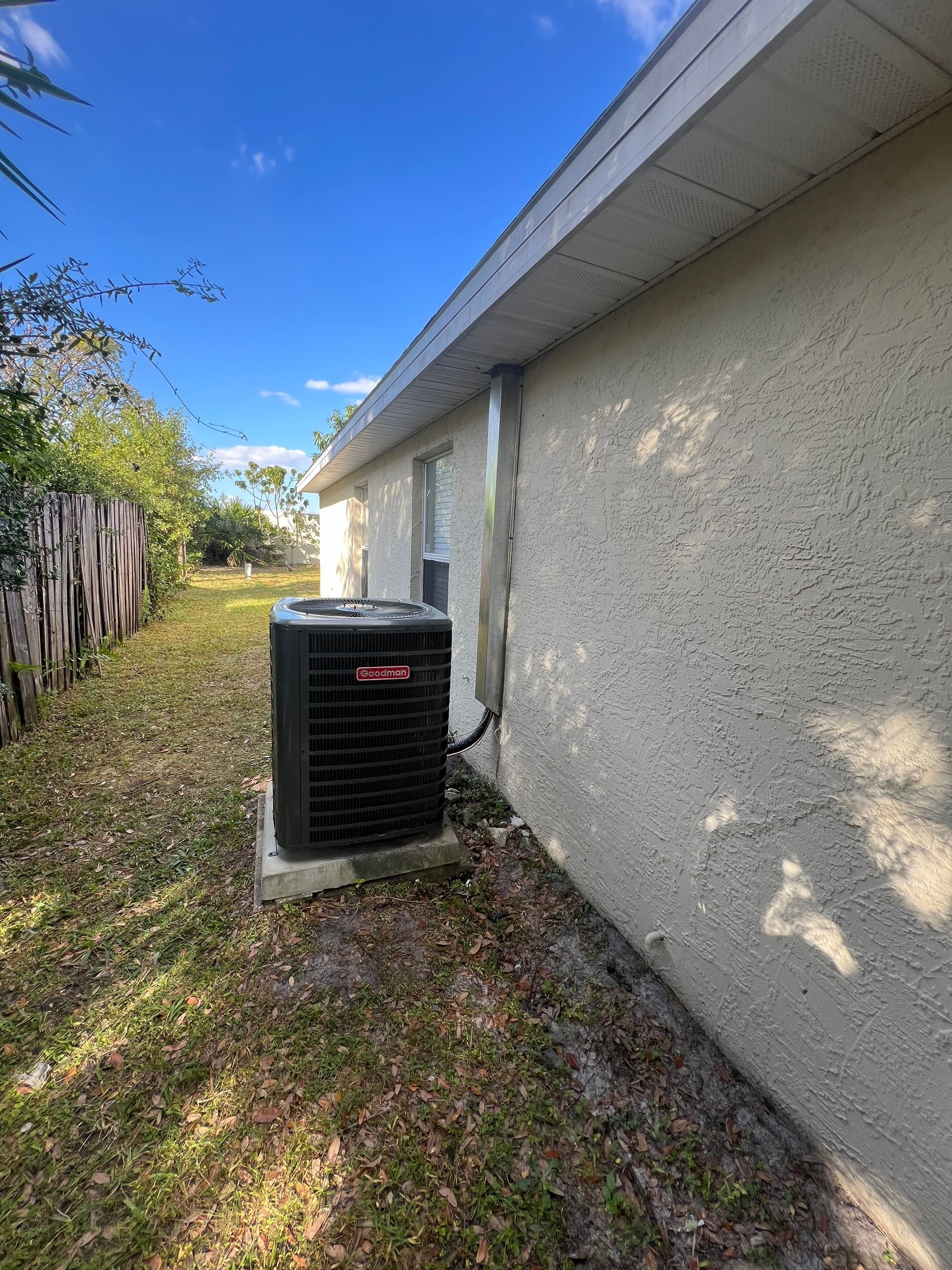 an air conditioner is sitting on the side of a house .