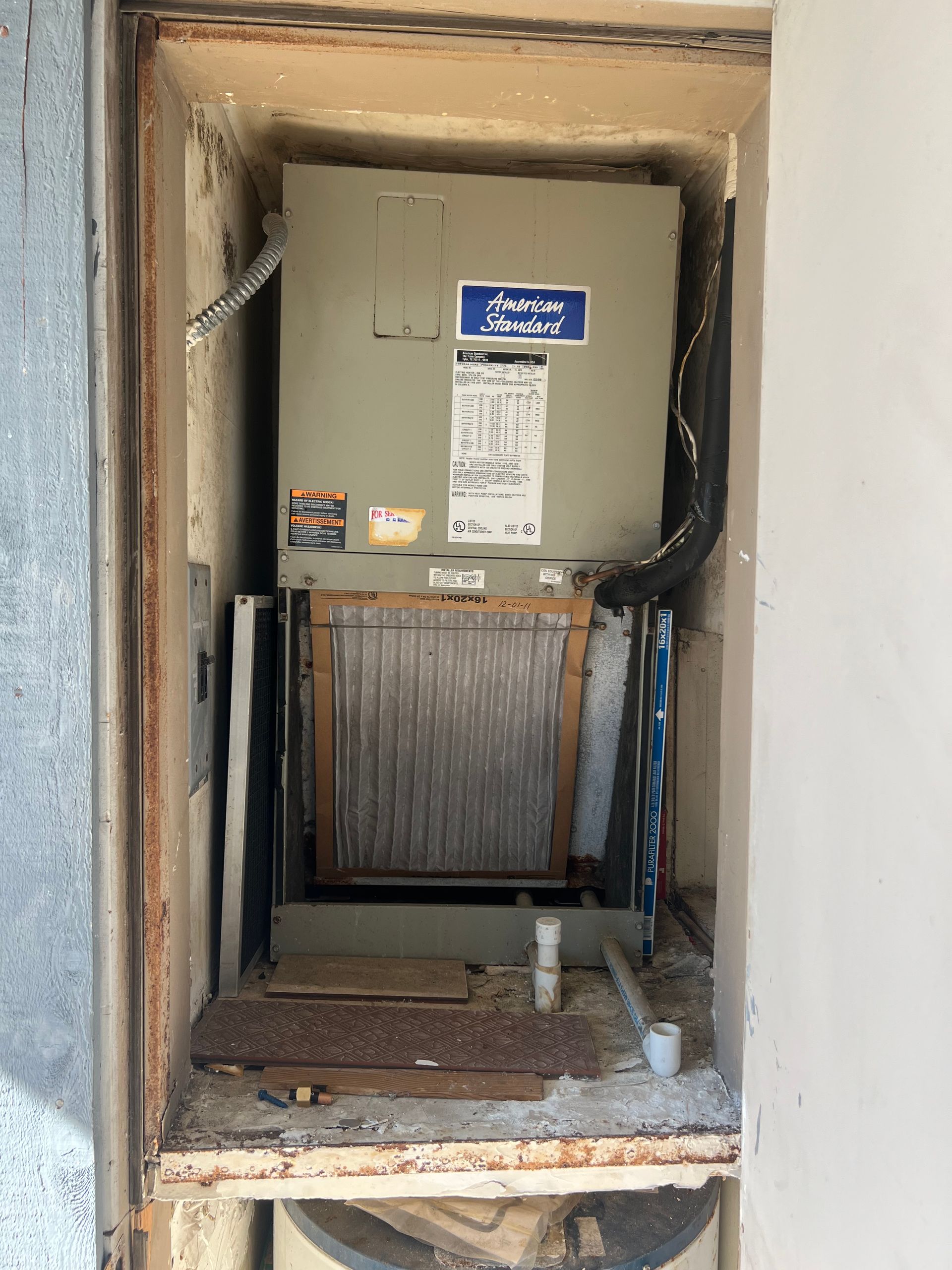 an air conditioner is sitting inside of a doorway .