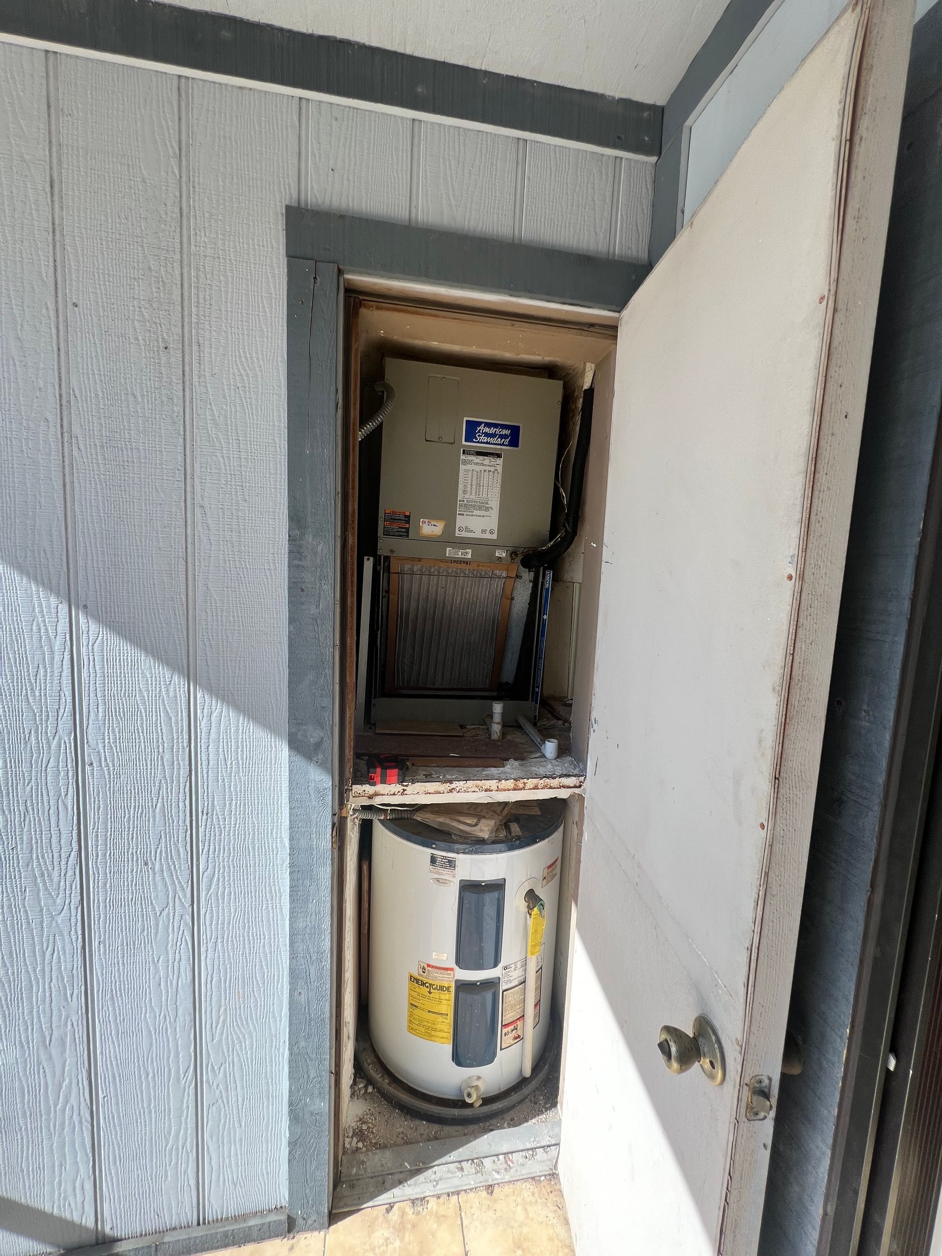 a water heater is sitting inside of a doorway on the side of a building .