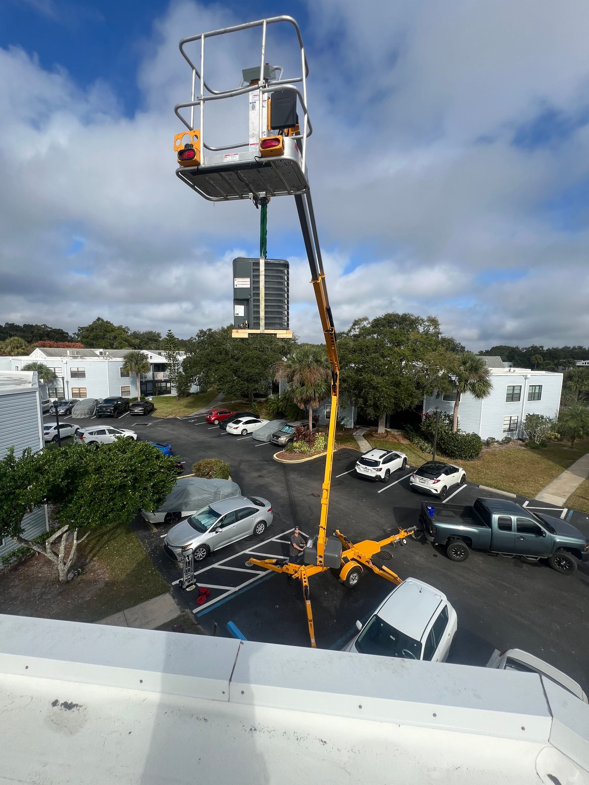 a crane is being used to lift a large object in a parking lot .