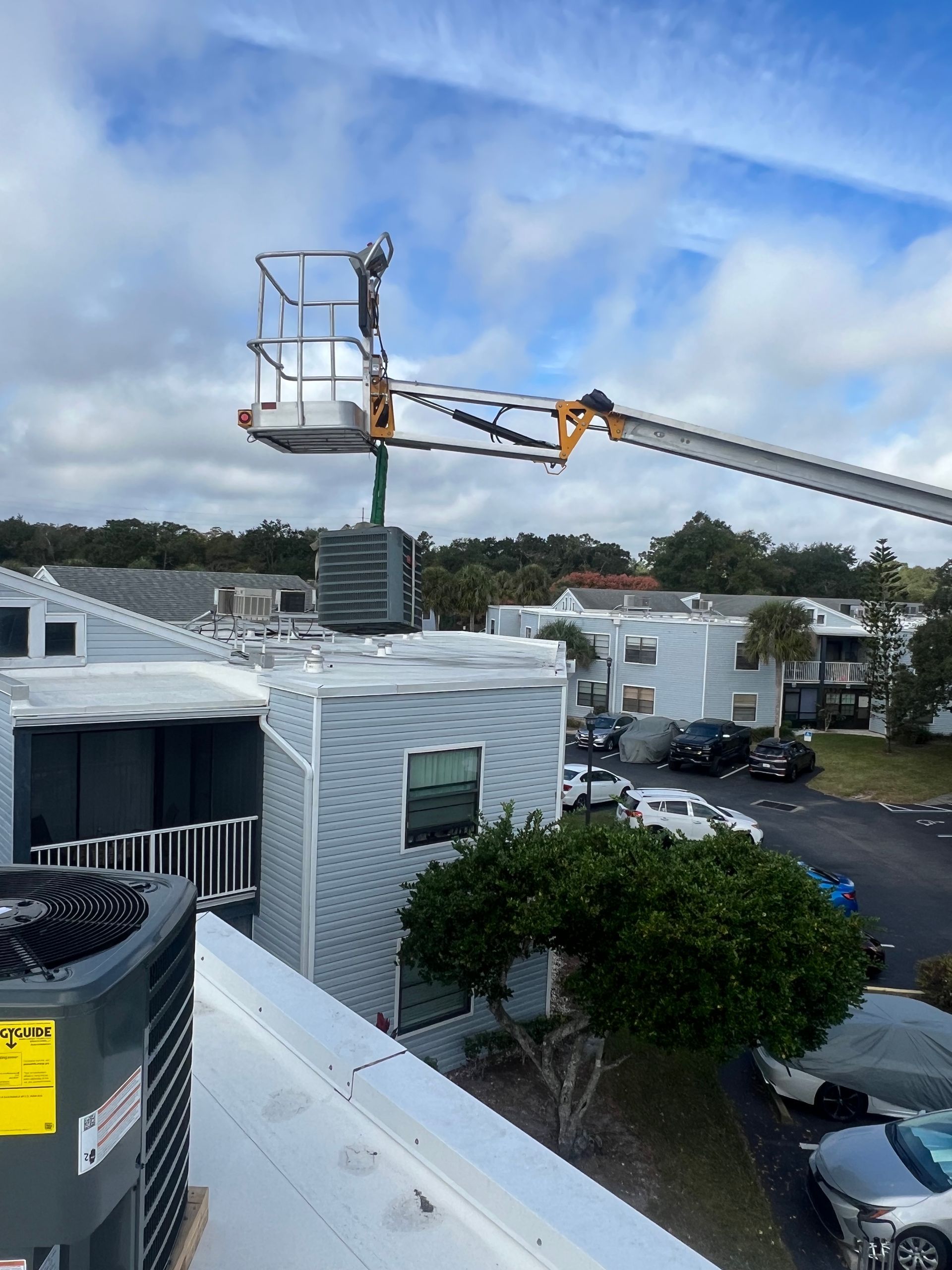 a man is standing in a bucket on top of a building .