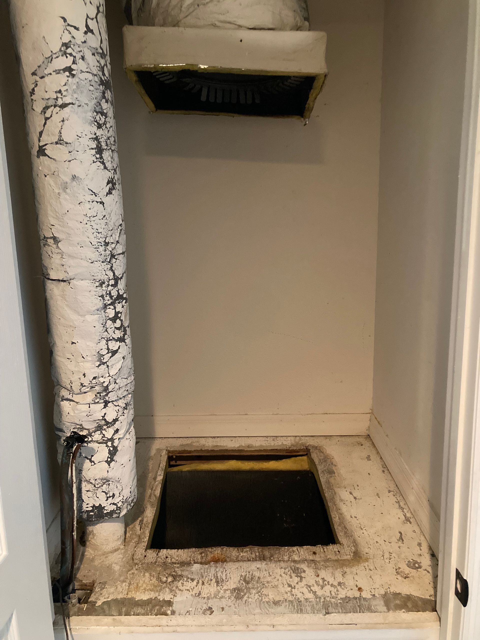 there is a hole in the floor in the corner of the room .