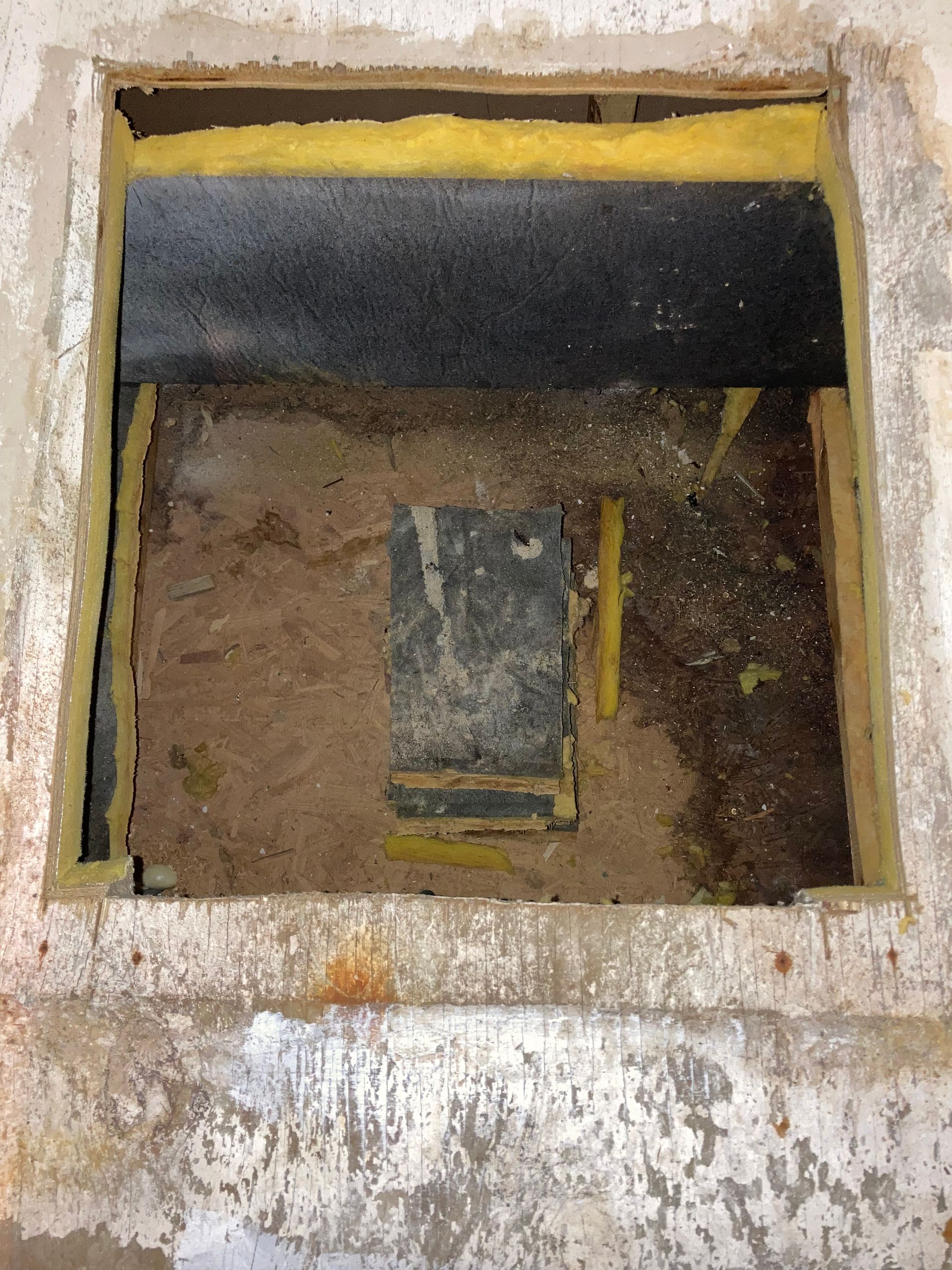 a hole in a wall with a piece of wood in it .