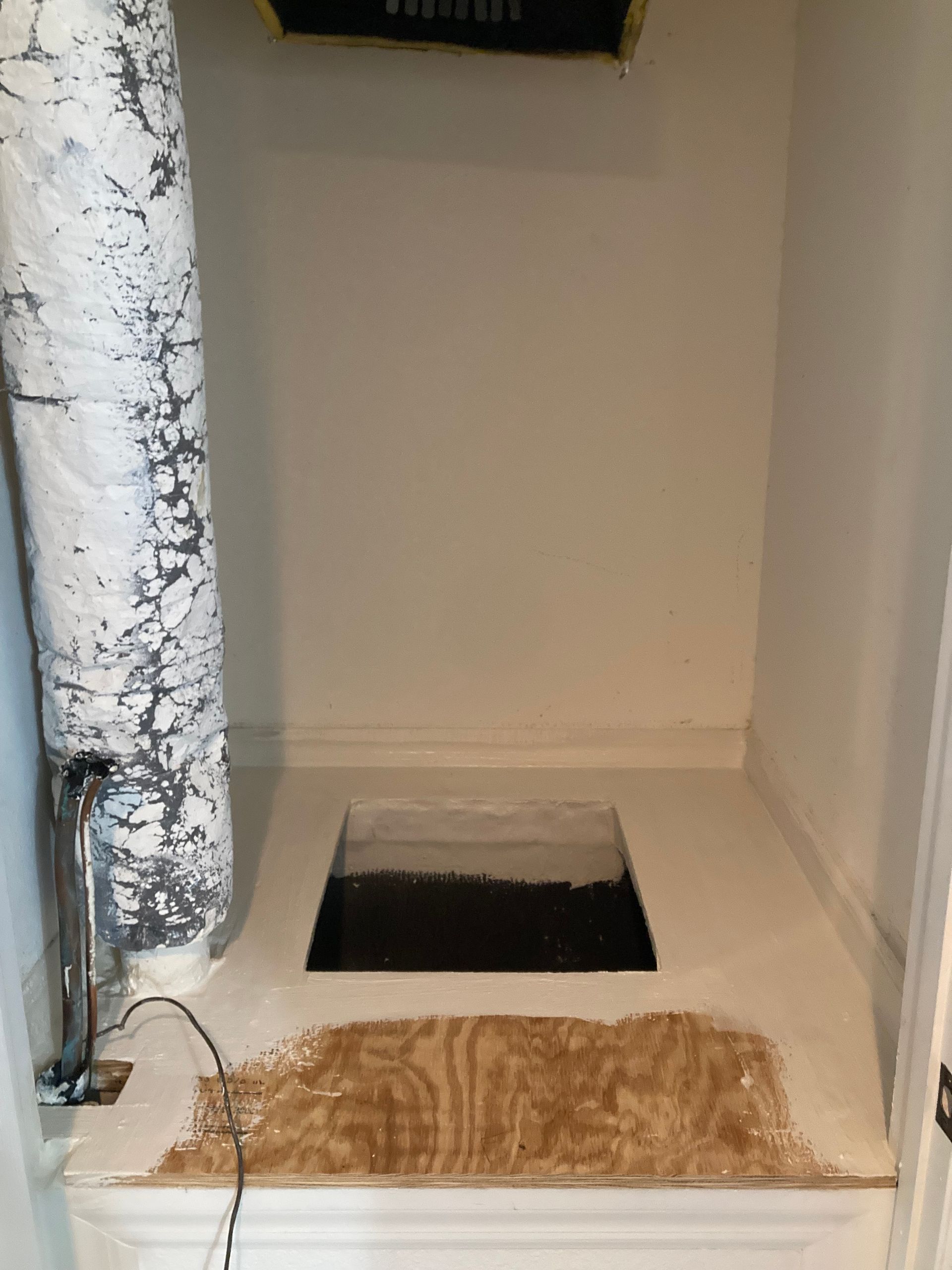 there is a hole in the floor in the corner of the room .