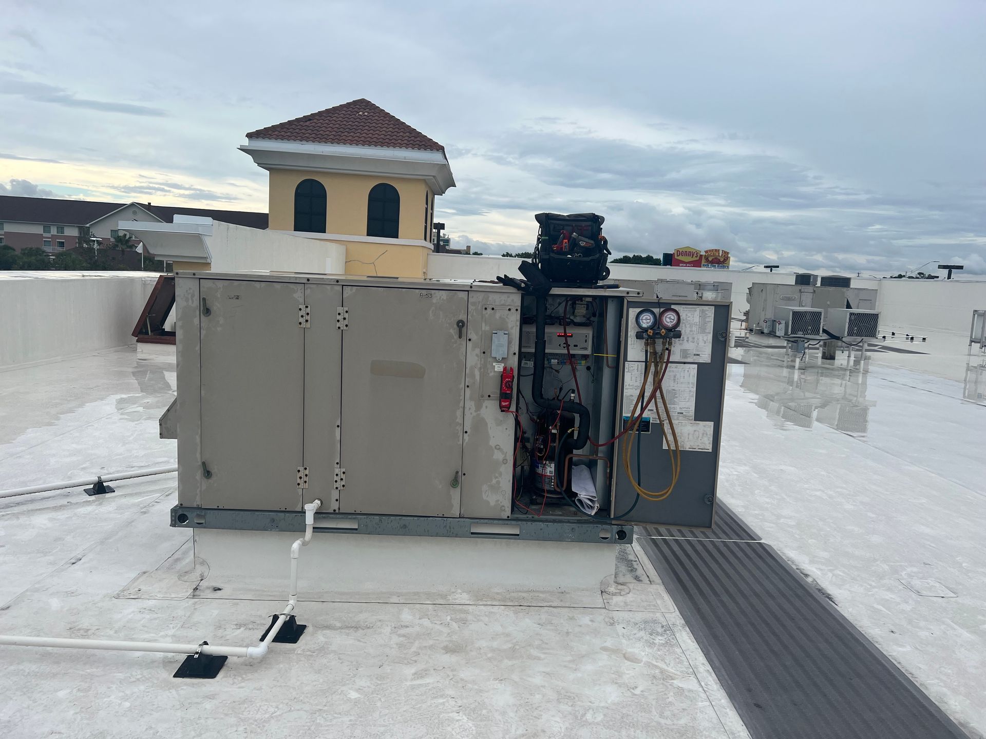 an air conditioner is sitting on top of a white roof .