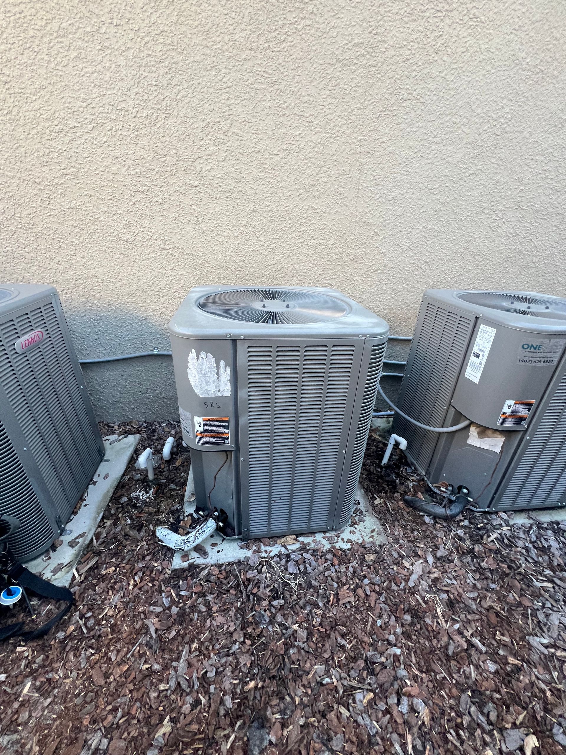 three air conditioners are sitting next to each other in front of a building .
