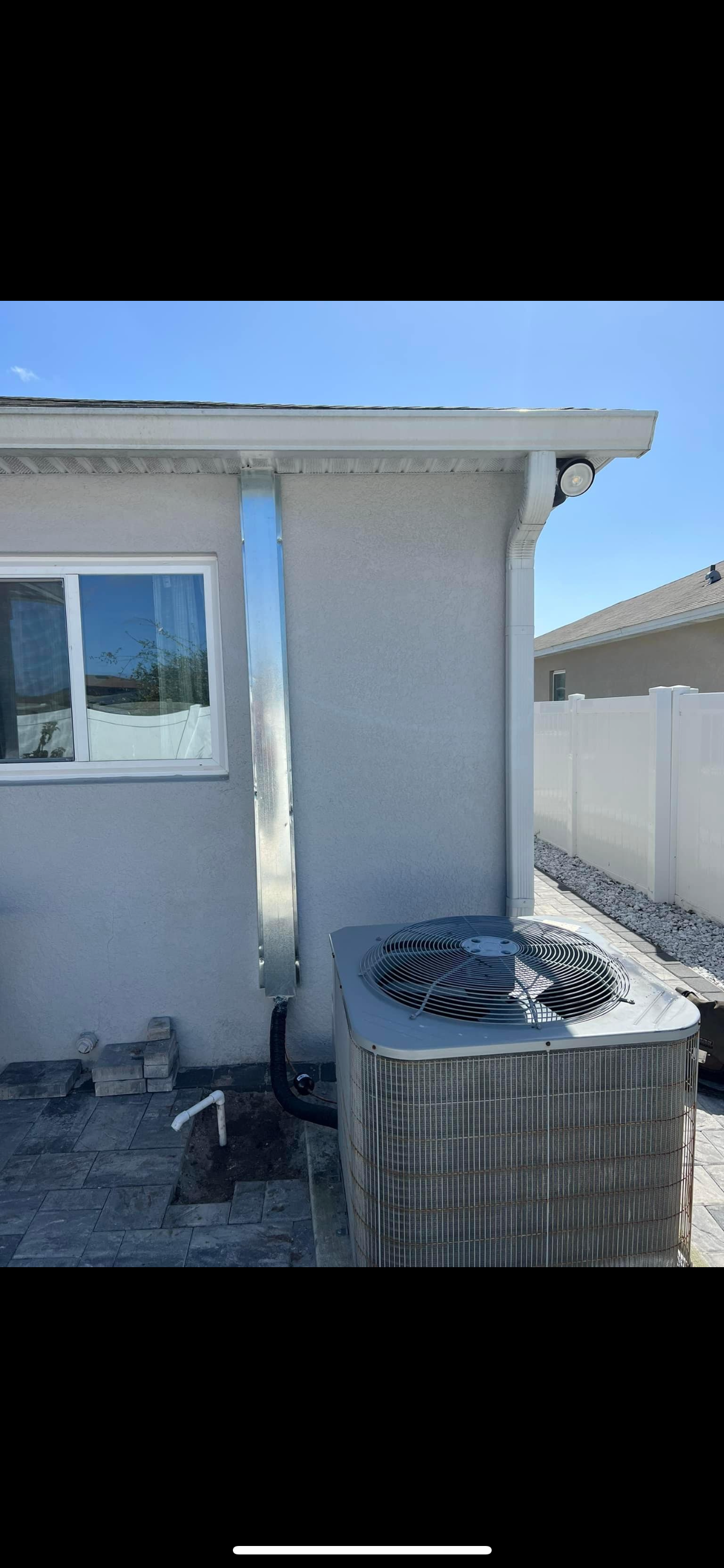 a house with a window and an air conditioner on the side of it .