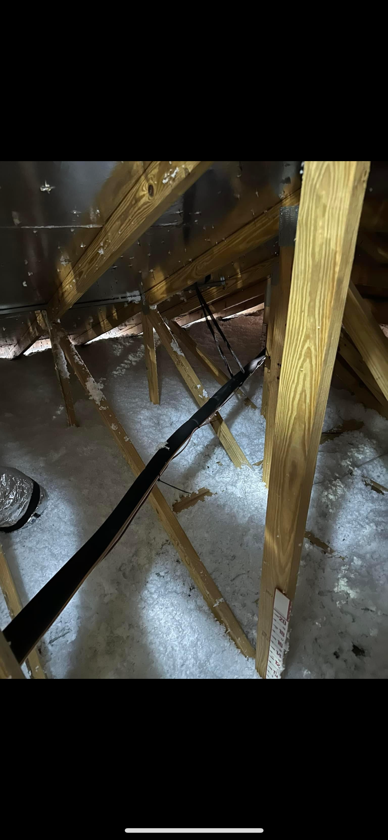 a person is using a vacuum cleaner to clean the attic of a house .