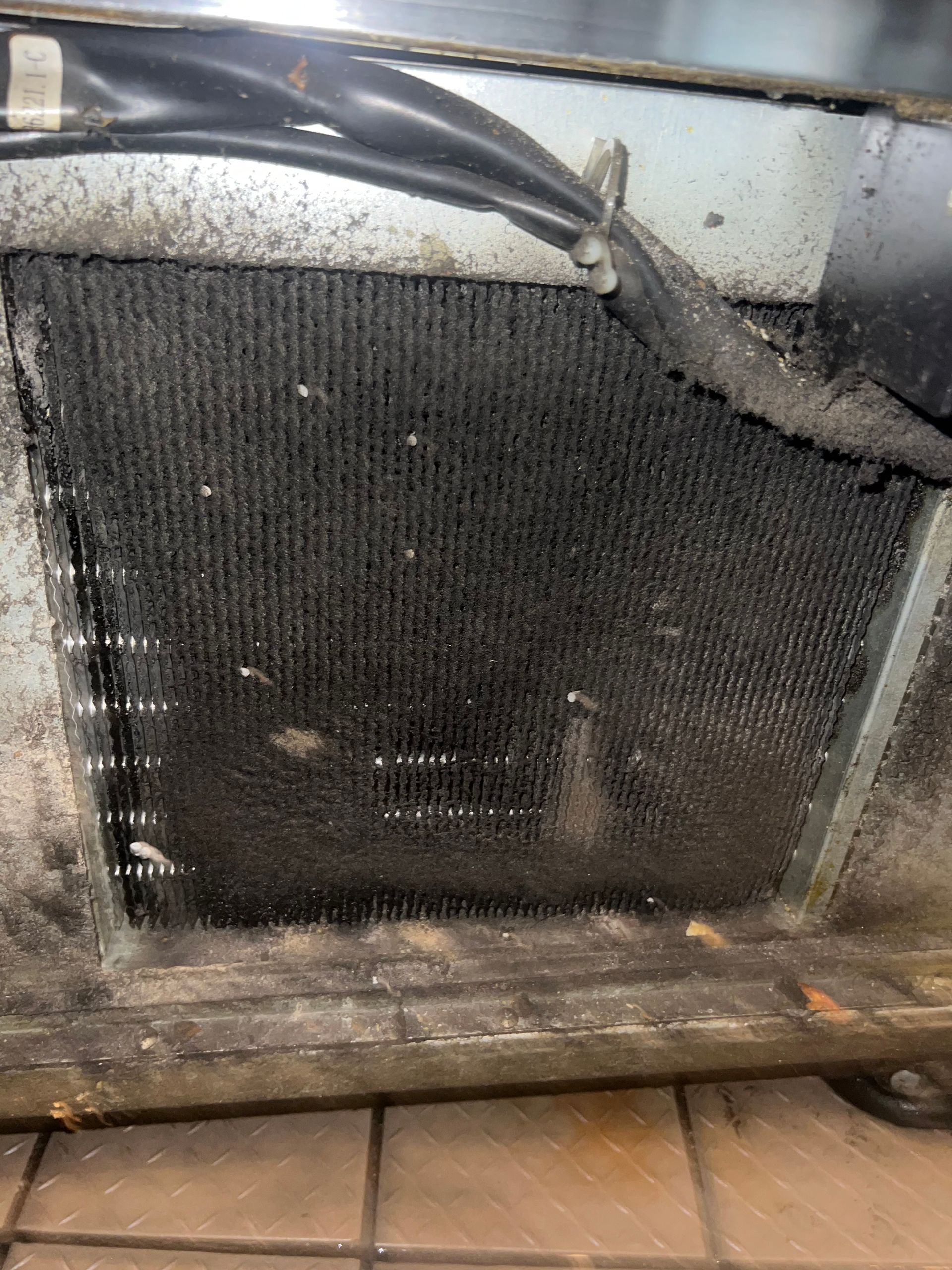a close up of a dirty radiator on a tiled floor .