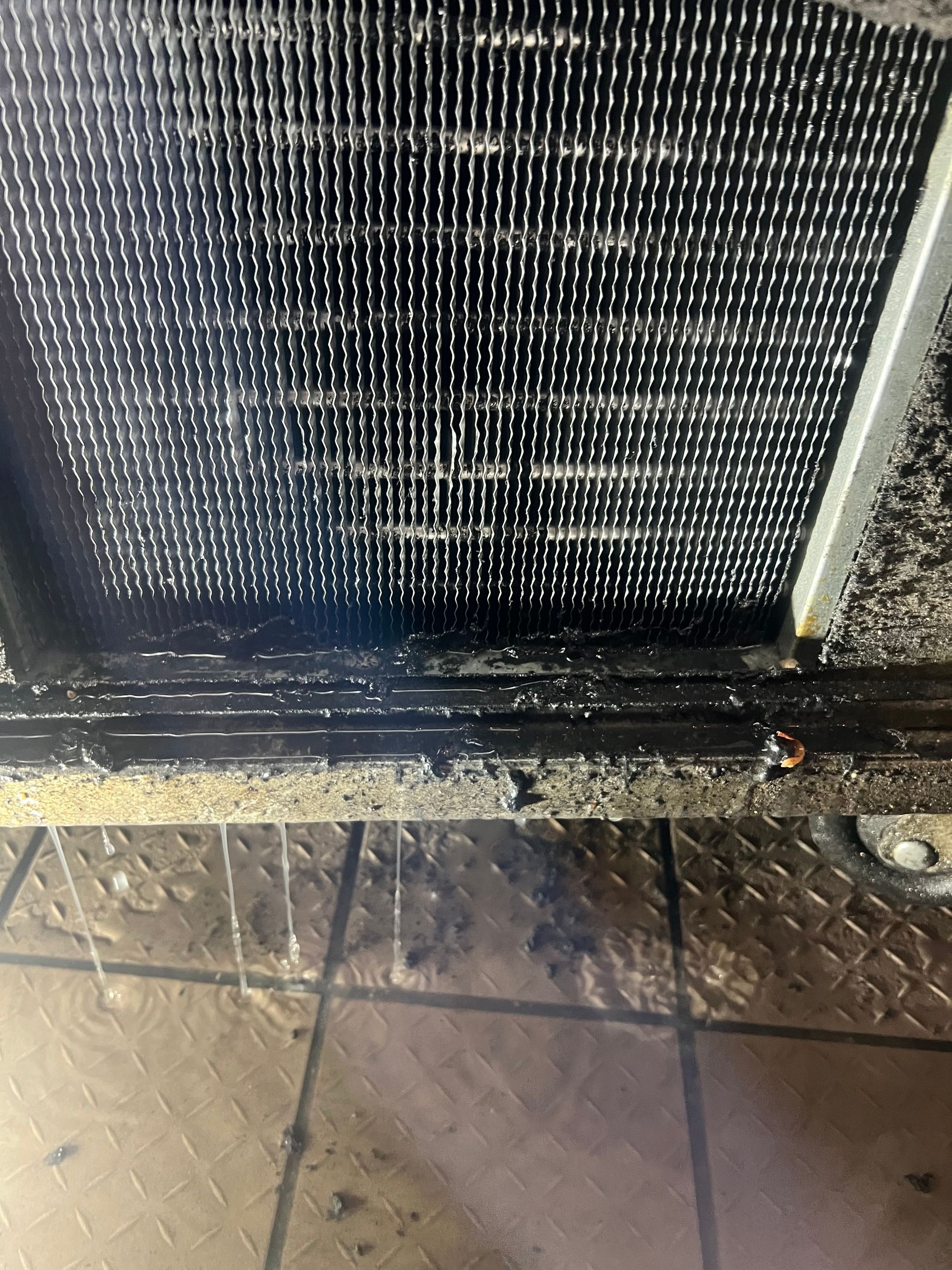 a close up of a dirty radiator on a tiled floor .