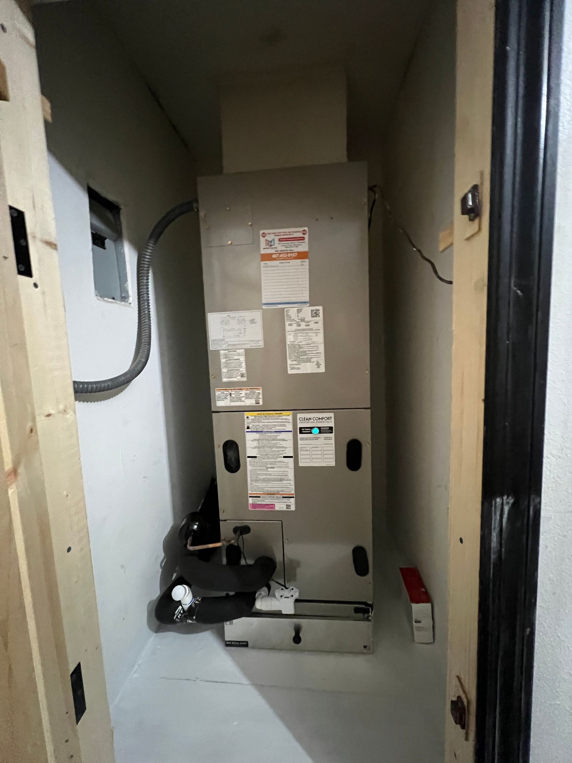 an air conditioner is sitting in a closet next to a door .