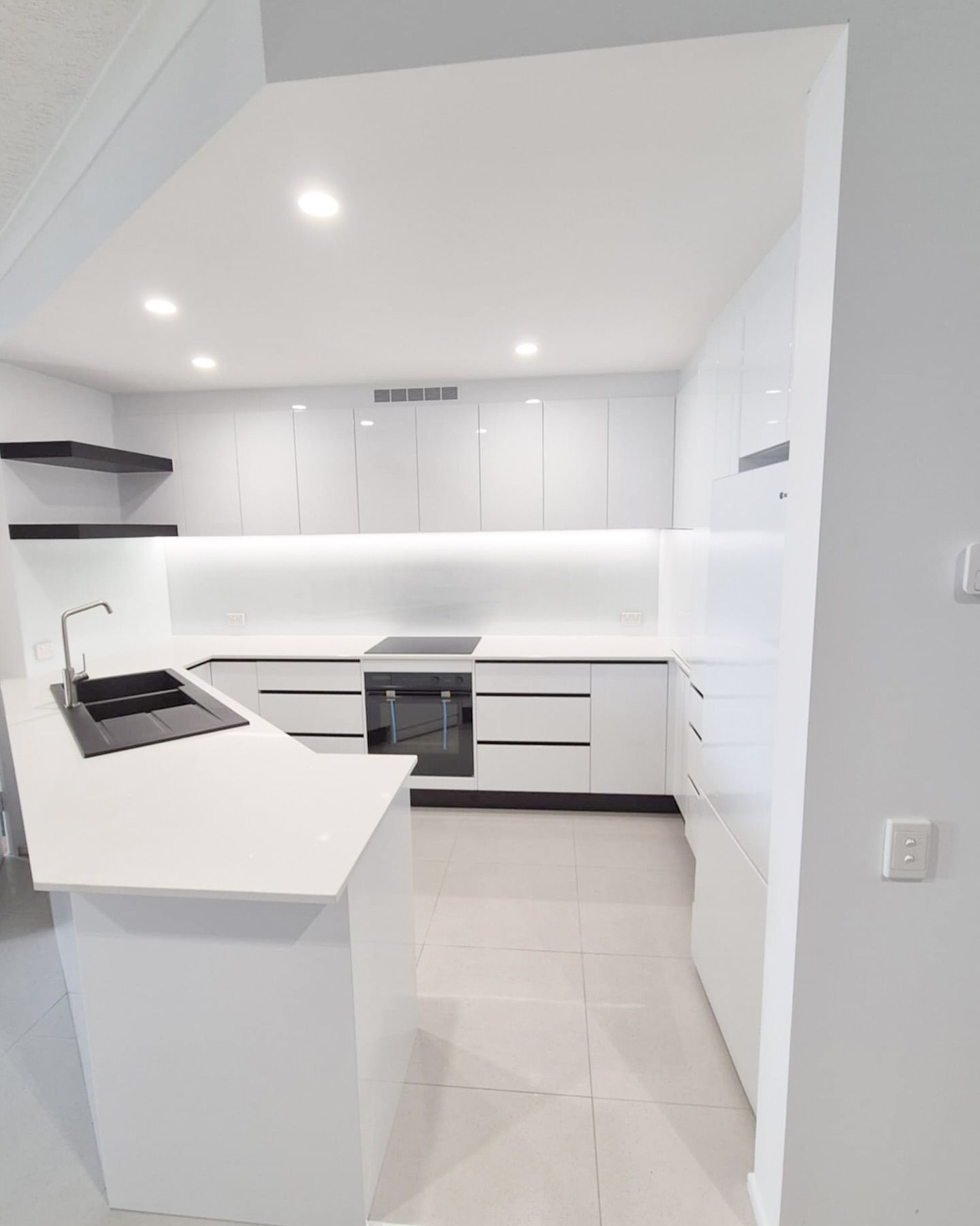 A Kitchen With White Cabinets And A Black Stove Top Oven — Reynolds Built In Dicky Beach QLD