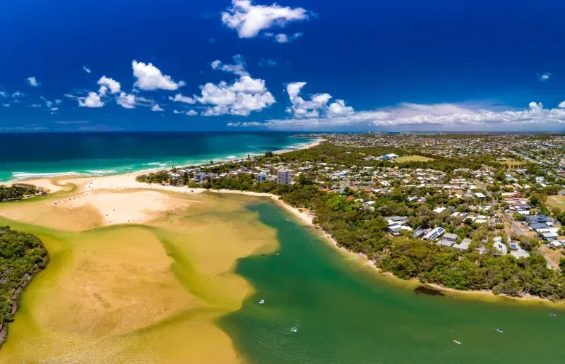 Aerial view of a sunny coastal town where a river meets the ocean — Reynolds Built In Currimundi, QLD 