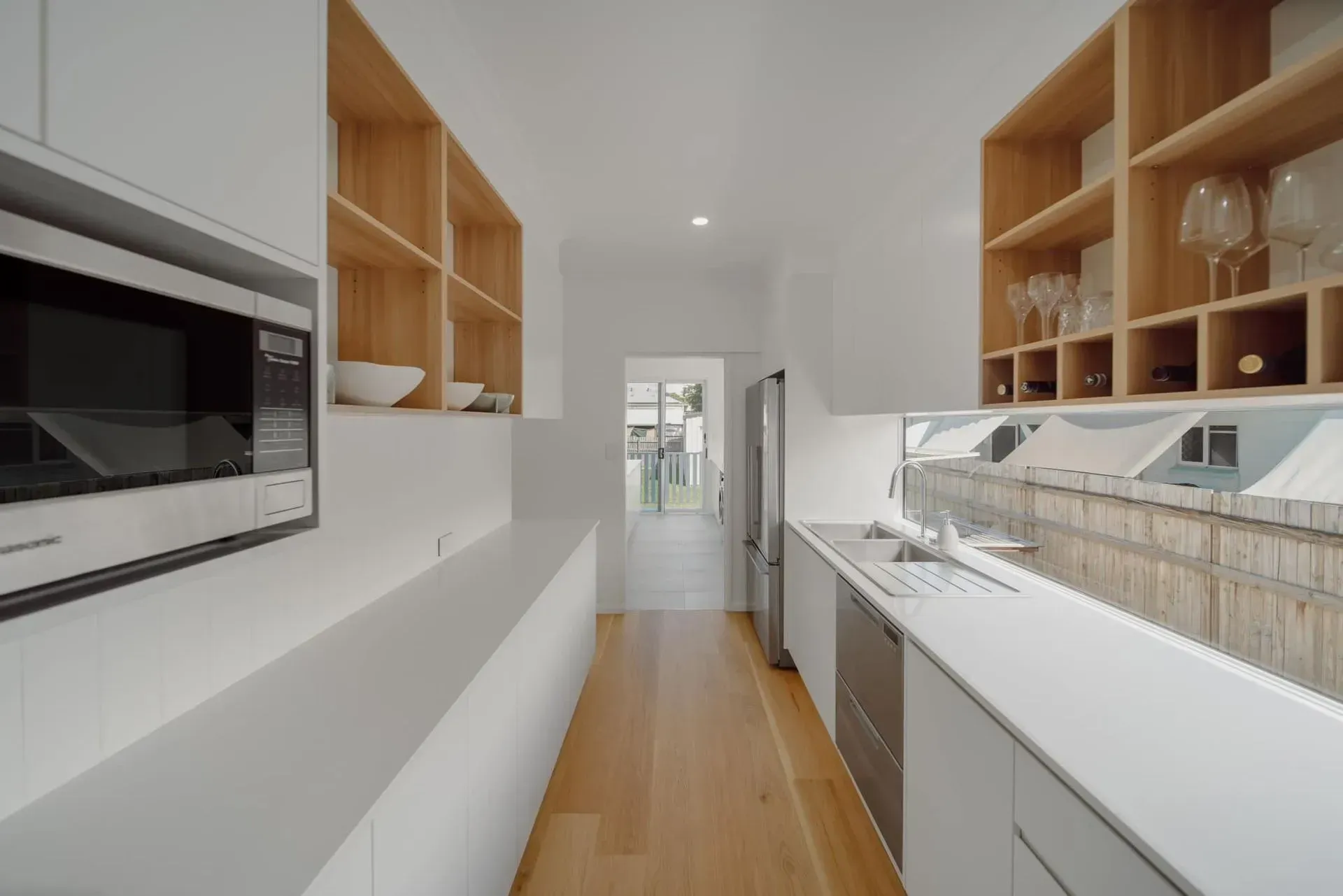 A Long Kitchen With White Cabinets And Wooden Shelves  — Reynolds Built In Moffat Beach, QLD