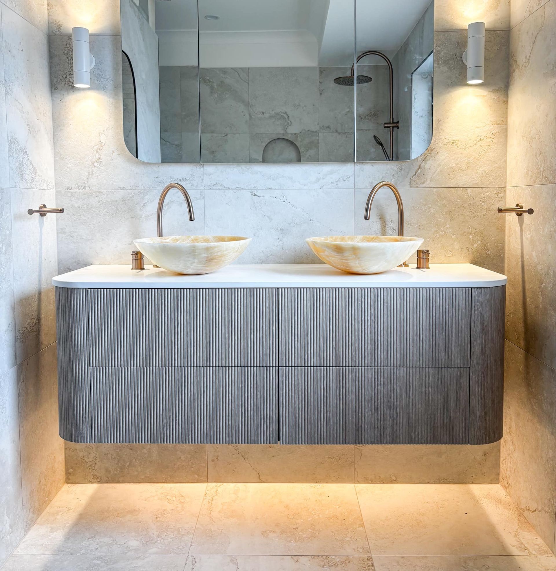 Modern bathroom vanity with double vessel sinks, mirror, wall sconces, and warm accent lighting — Reynolds Built In Caloundra, QLD
