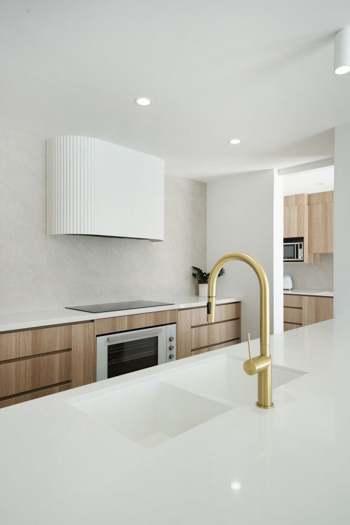 A Modern Kitchen Features a White Island With a Brass Faucet — Reynolds Built In Moffat Beach, QLD
