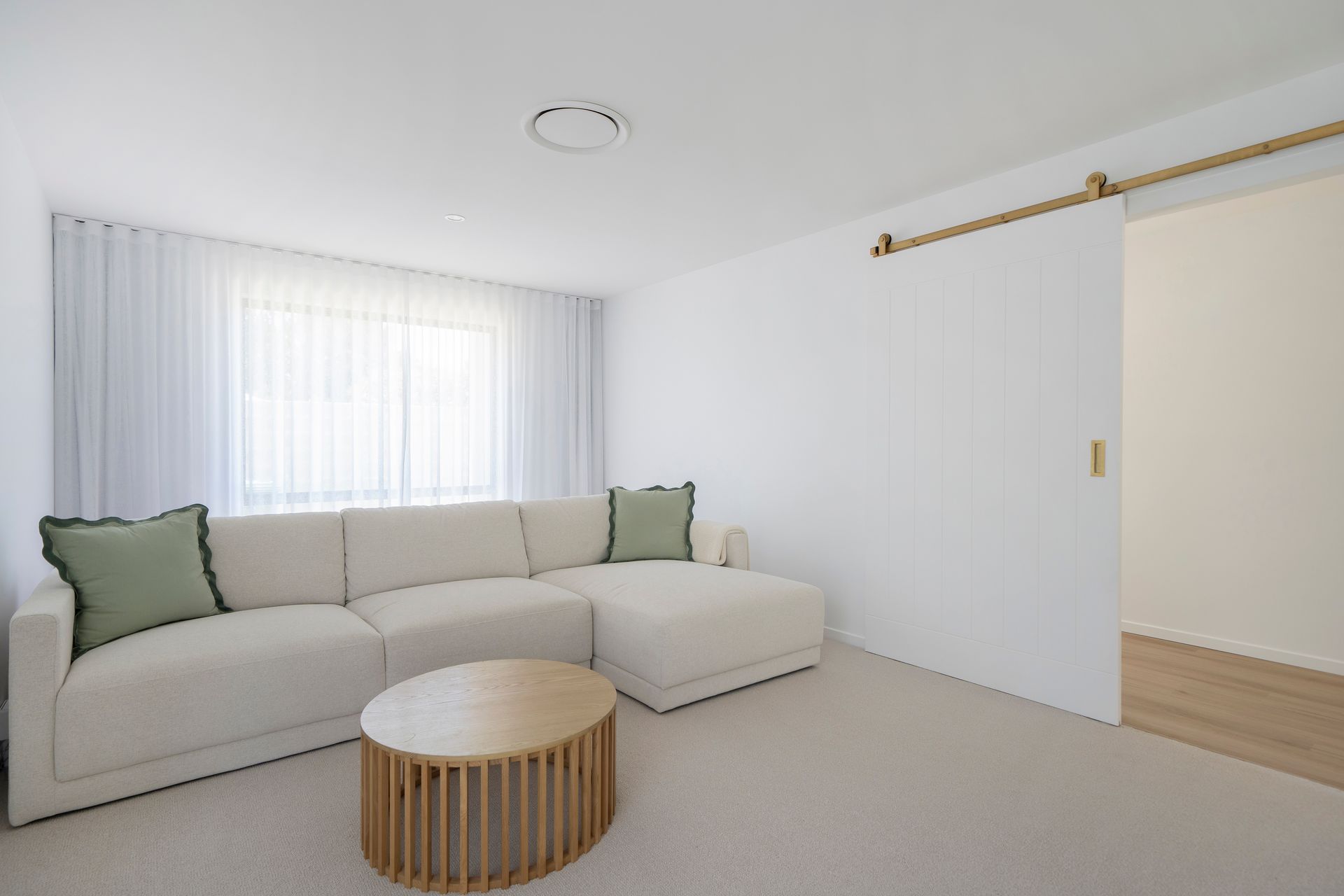 Living Room With a White Sectional Sofa and Green Pillows — Reynolds Built In Dicky Beach, QLD