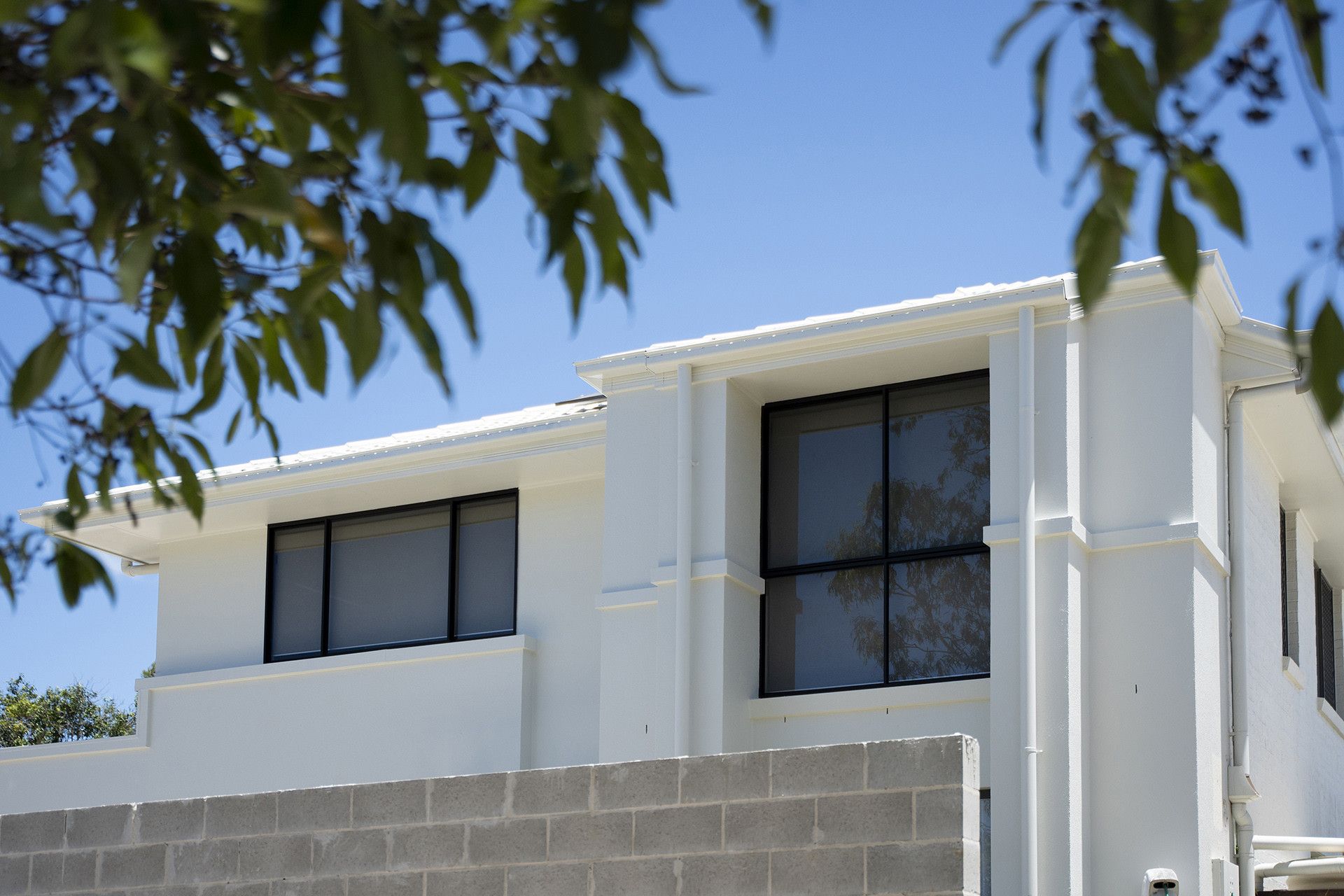A White, Two-Story House With Black-framed Windows — Reynolds Built In Golden Beach, QLD