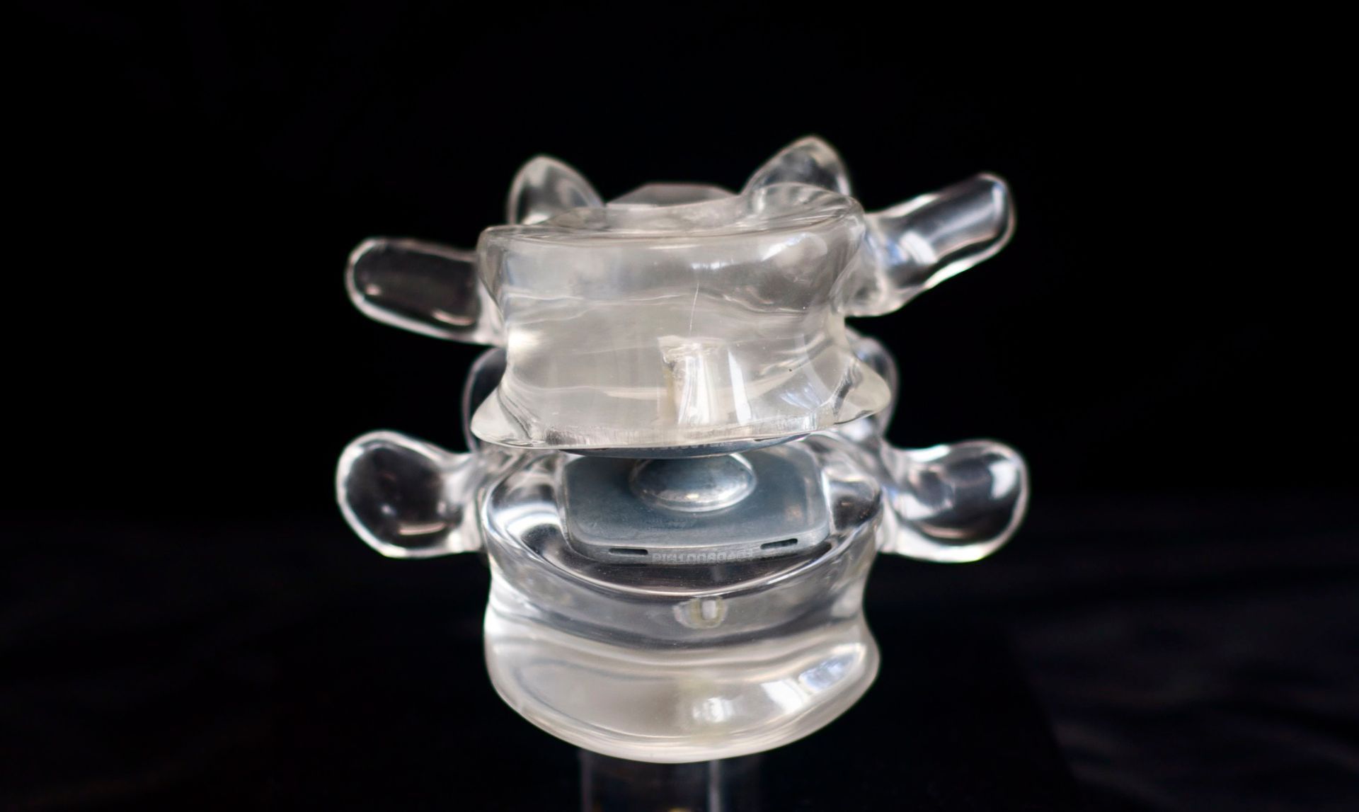 A close up of a clear plastic object on a black background.