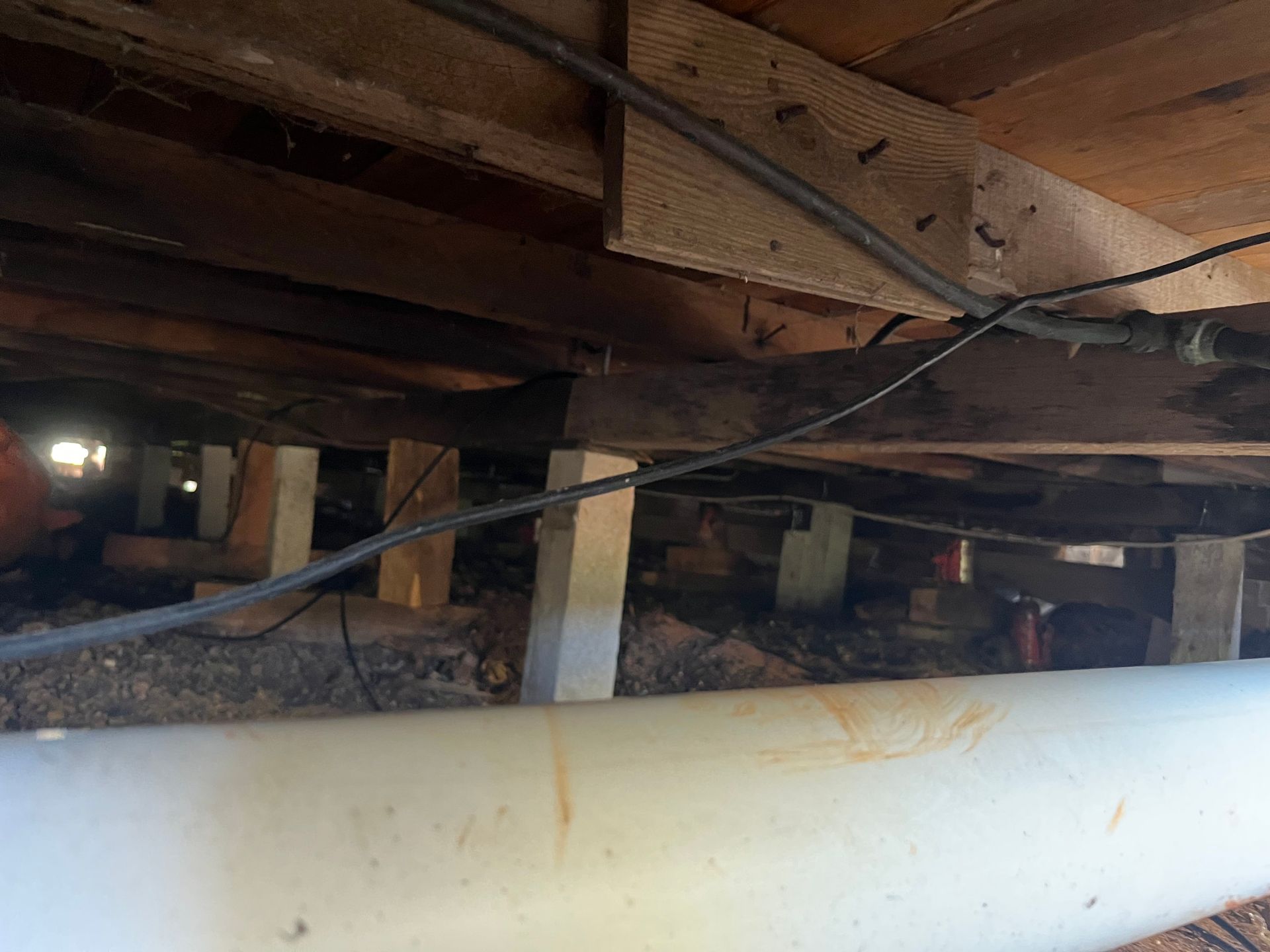 A pipe is hanging from the ceiling of a wooden structure.