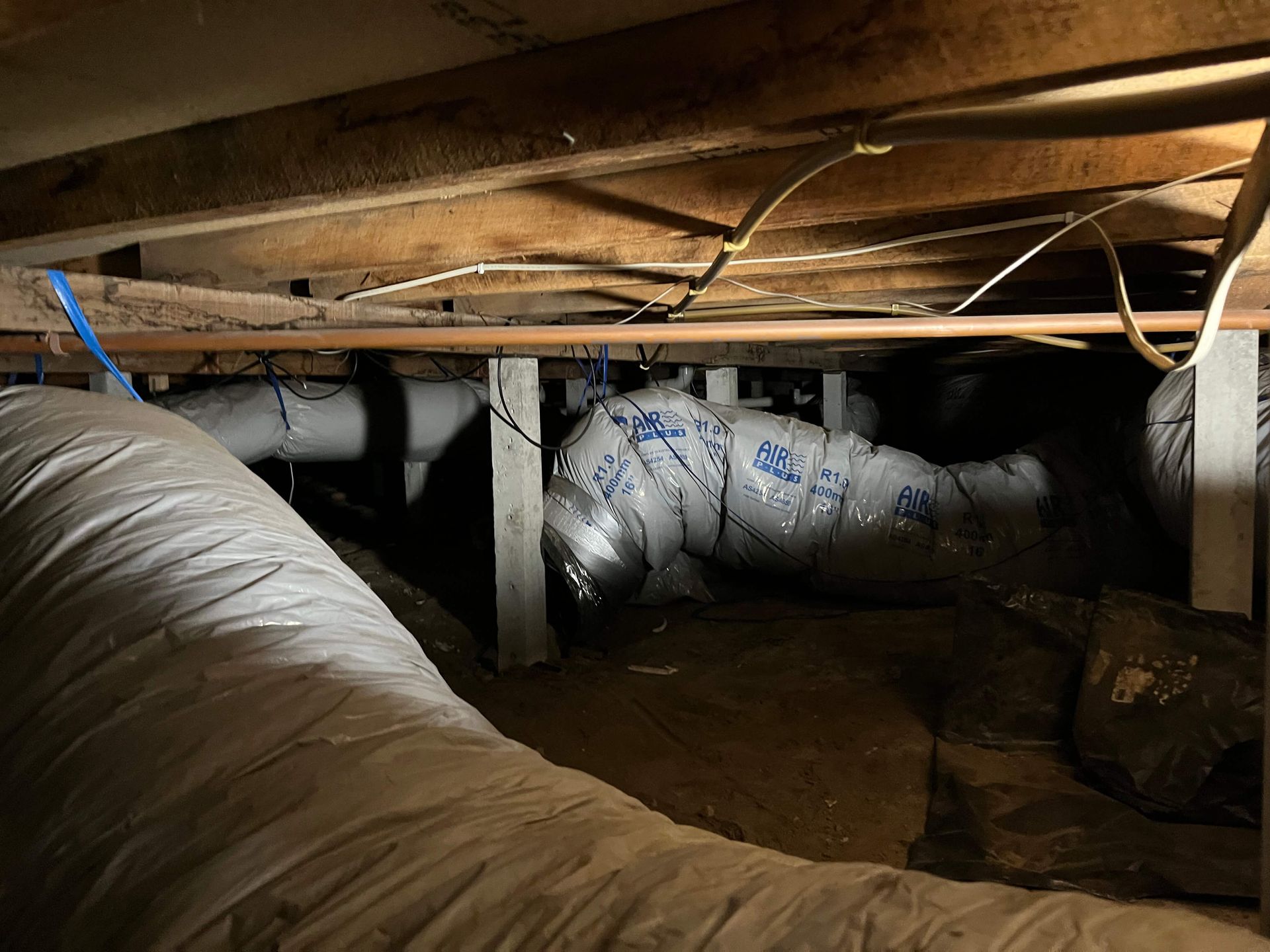 A bunch of pipes are coming out of the ceiling of a house.