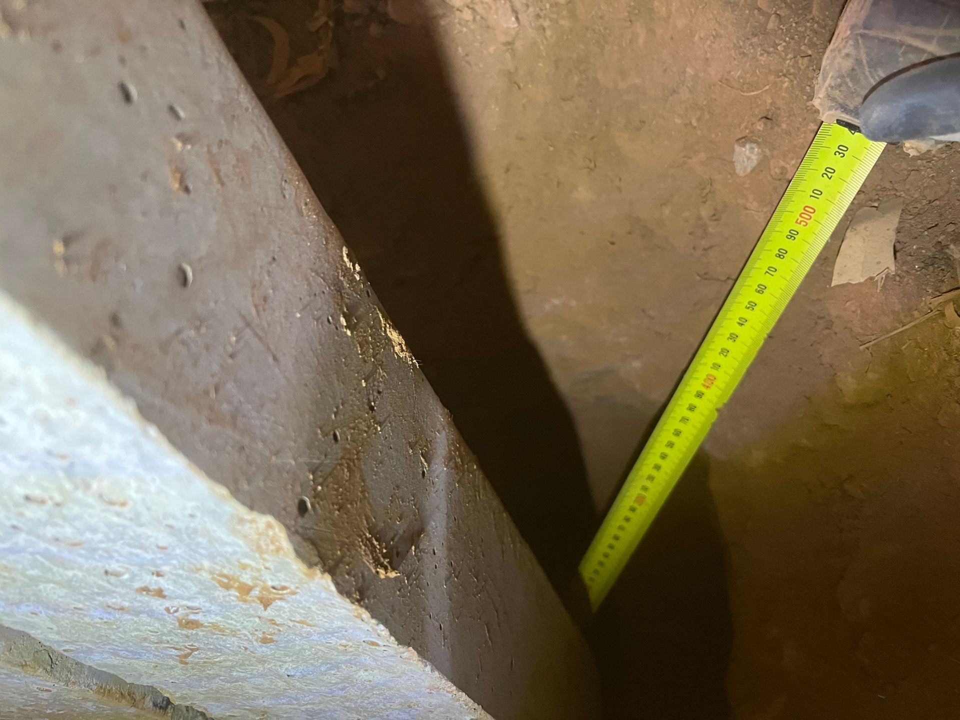 A person is measuring a pipe with a tape measure.