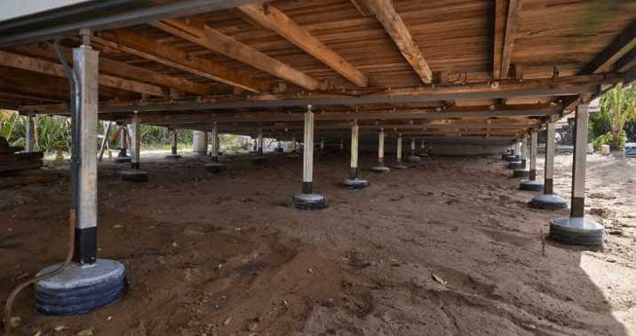 The foundation of a house is being built underneath it.