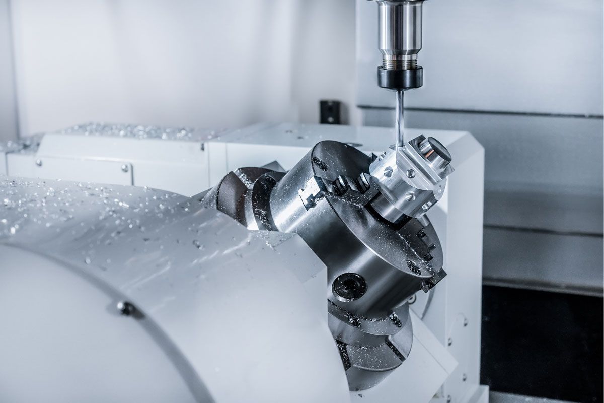 CNC machine cutting metal, spraying coolant, in a workshop setting.