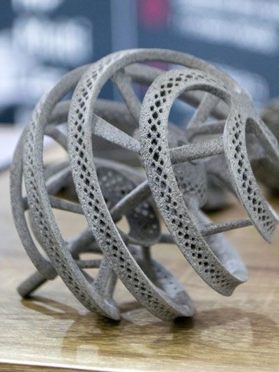 Metallic, spiral-shaped structure with patterned details; possibly a 3D-printed component.