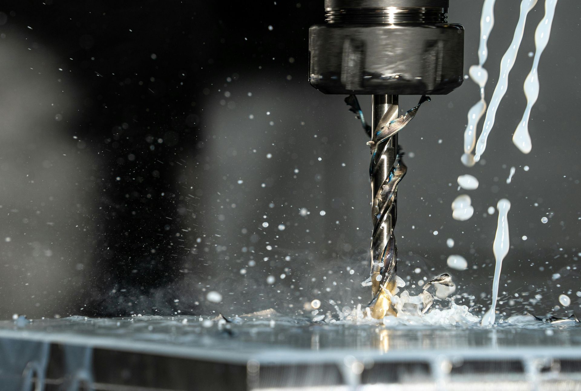 End mill drilling metal with coolant splashing.