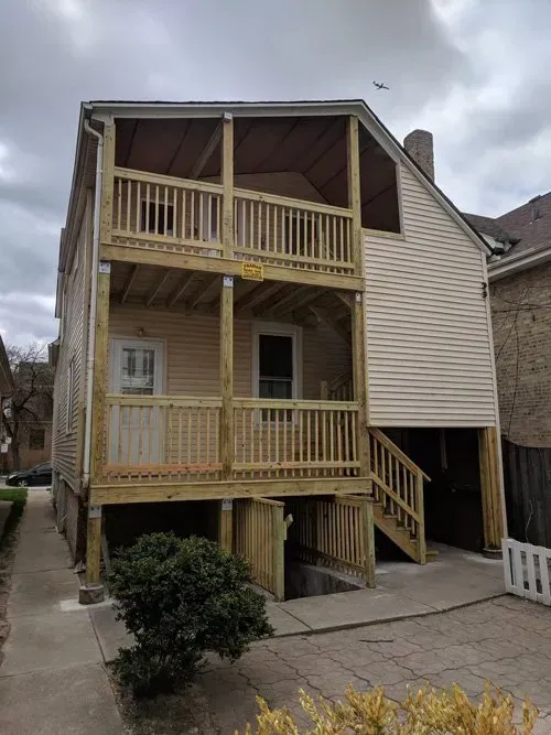 A house with a wooden deck and stairs.