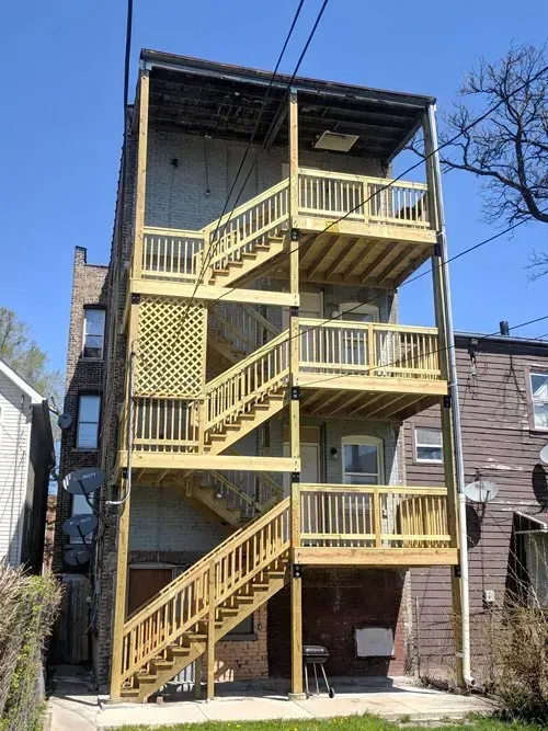 A building with a wooden deck and stairs on it.