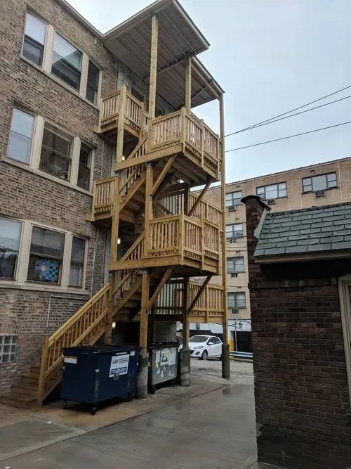 A building with a wooden staircase on the side of it.