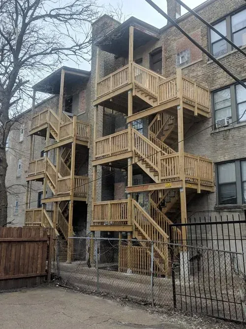 A building with wooden stairs on the side of it.