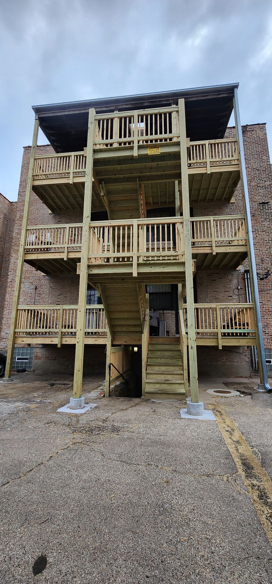 A building with a wooden deck and stairs on the side of it.