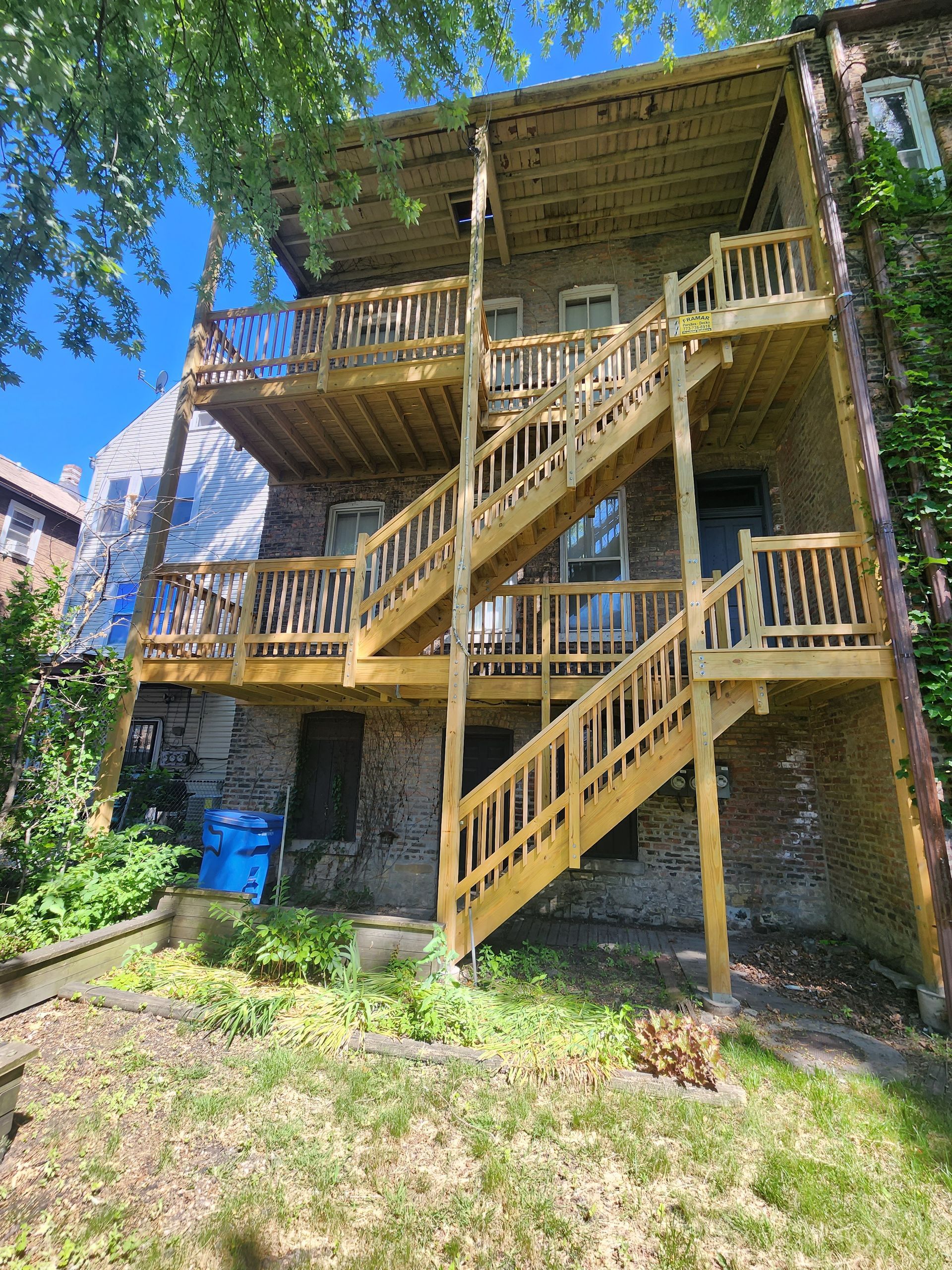 A large brick building with a wooden deck and stairs.