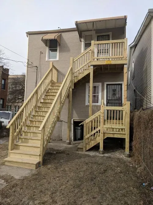 A house with wooden stairs leading up to the second floor.