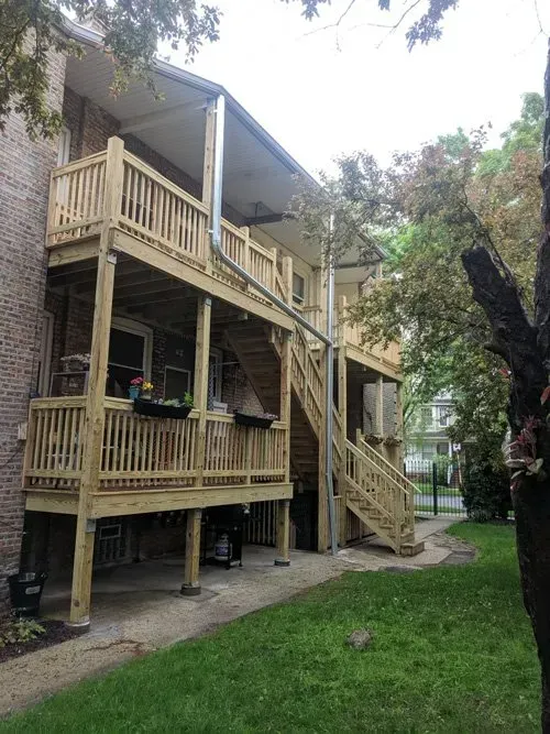 A house with a wooden deck and stairs.
