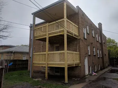 A brick building with a wooden deck on the side of it.