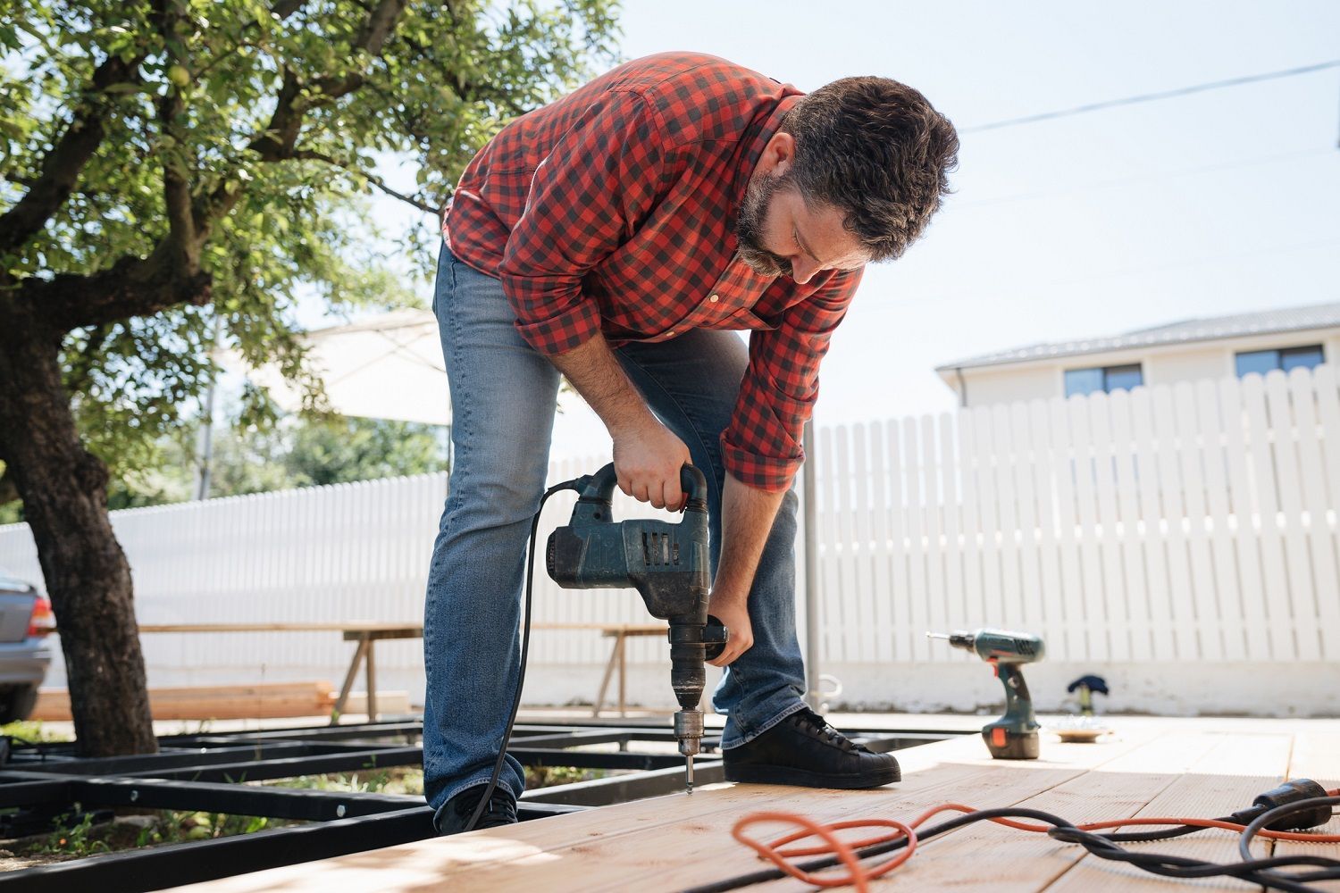 Carpenter installing a wood floor outdoor terrace in new house construction site.