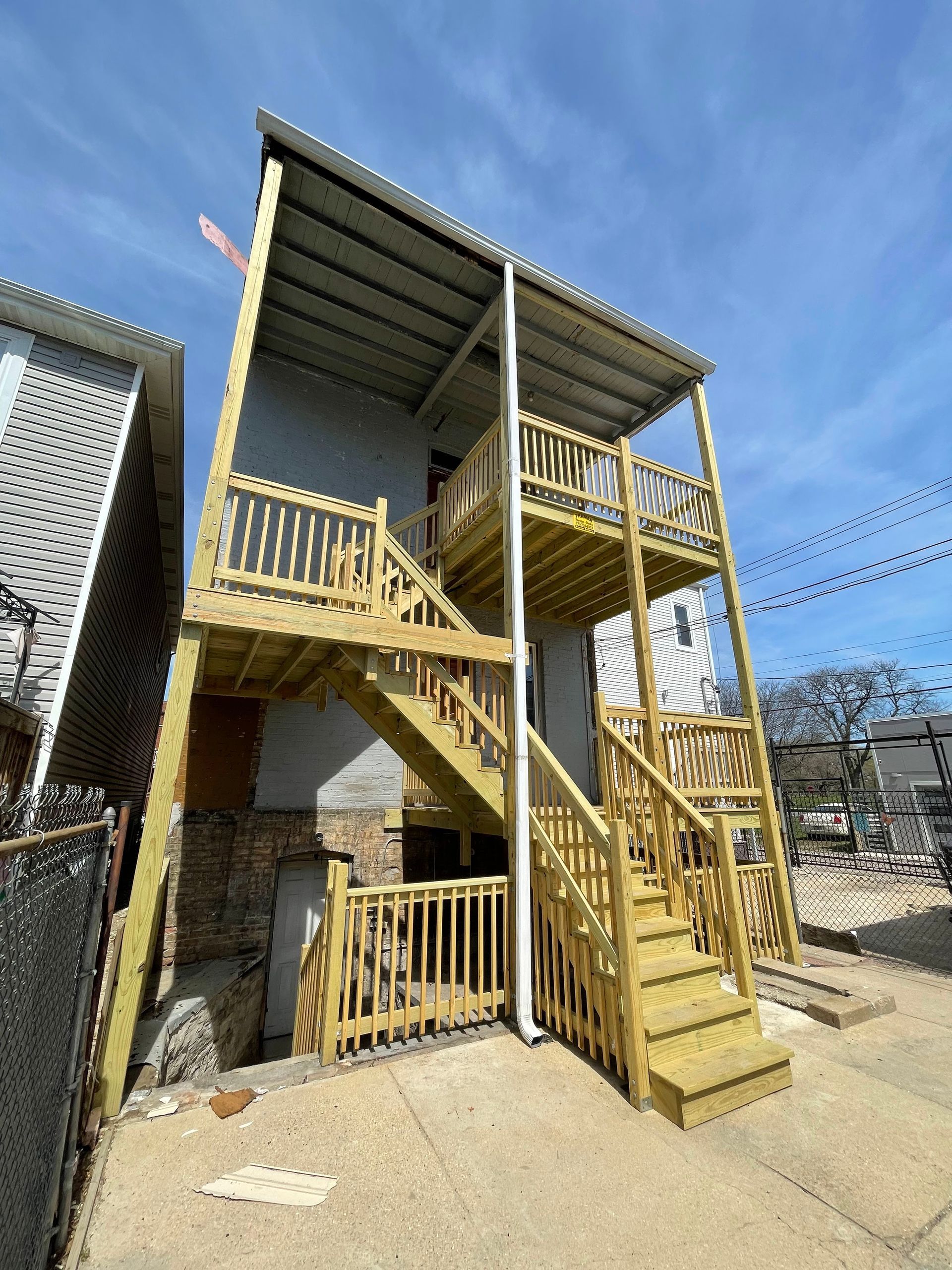 A house with a wooden deck and stairs on the side of it.